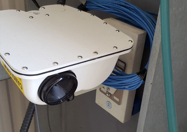 photo of a video surveillance camera installed at an industrial work site with a rugged cover for ultimate protection and performance