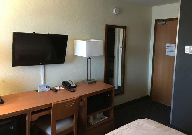 photo of a hotel room with a wall-mounted television, a hospitality service offered by Innovative